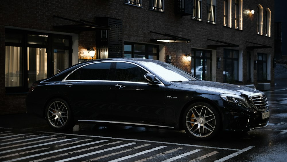 Black Mercedes S-Class parked outside a hotel