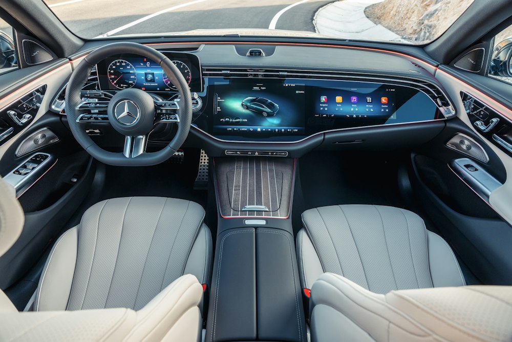 Modern Mercedes-Benz interior with wide digital screen and white leather seats